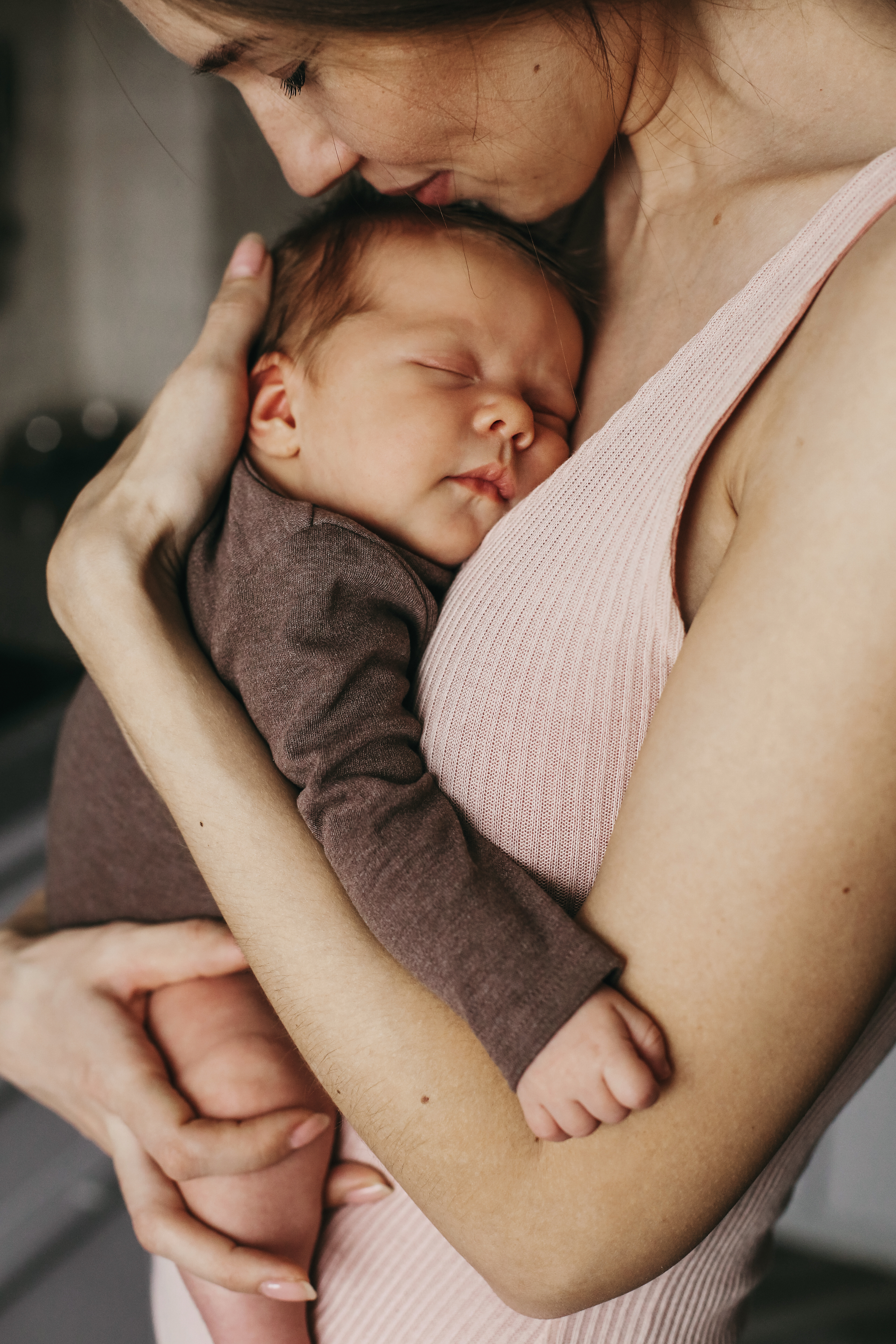 Maman tenant tendrement son nouveau-né endormi contre sa poitrine, illustrant le lien profond et l’accompagnement postnatal au Cabinet Au Cœur de Soi Maman tenant tendrement son nouveau-né endormi contre sa poitrine, illustrant le lien profond et l’accompagnement postnatal au Cabinet Au Cœur de Soi